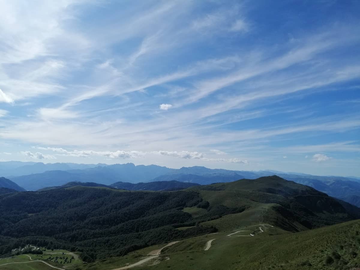 Summer view of Bjelasica mountain and hills, with green grass all around.